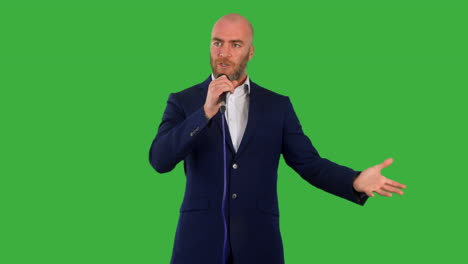 A-male-presenter-public-speakimg-on-stage-at-a-conference-with-green-screen-background