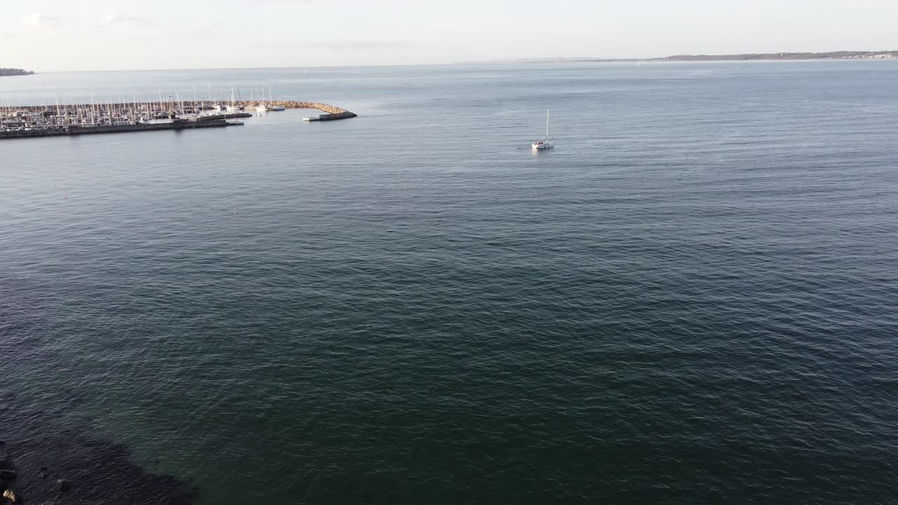 observando un mar báltico tranquilo bañando un muelle lleno de barcos anclados y la costa rocosa de helsingor en dinamarca en un día de otoño sin gente, vista aérea