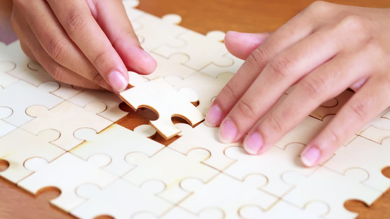 A close-up view of hands placing the final piece of a jigsaw puzzle symbolizing achievement and focus