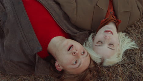 couple lying on autumn field and speaking