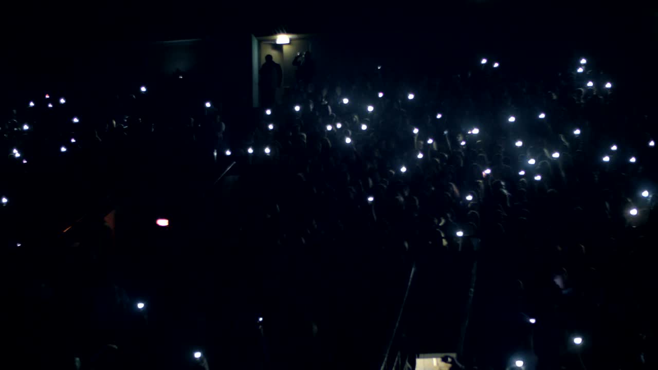 personas con luces en el concierto en la sala de música oscura