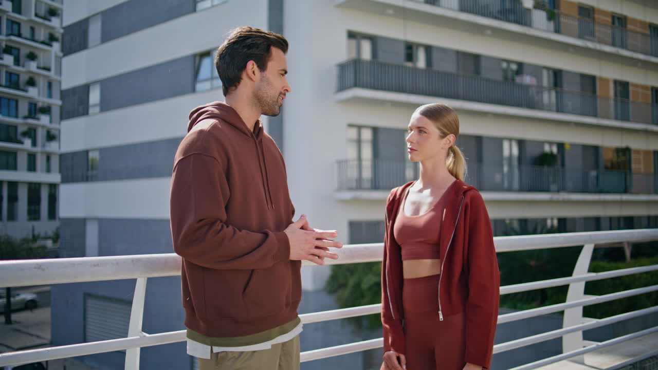 Sport couple talking outdoors closeup. Man discussing fitness goals in city
