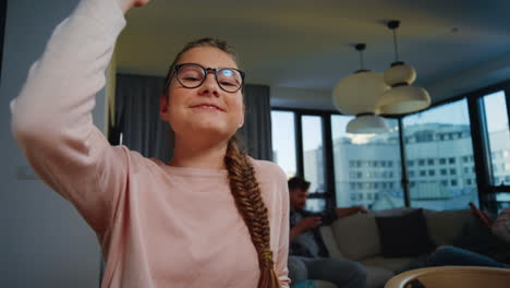 niña diligente que estudia en casa. niña con gafas levantando la mano durante la lección en línea