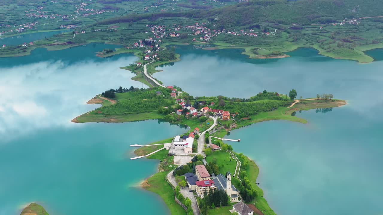 Birds eye view of semi circular Rama Lake surrounded by bays, islands and mountains on cloudy day. Offbeat destination