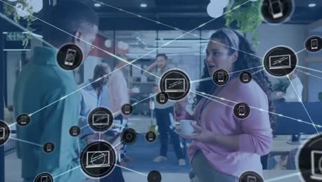 animación de iconos de portátiles y teléfonos conectados, diversos compañeros de trabajo tomando café y hablando en la oficina