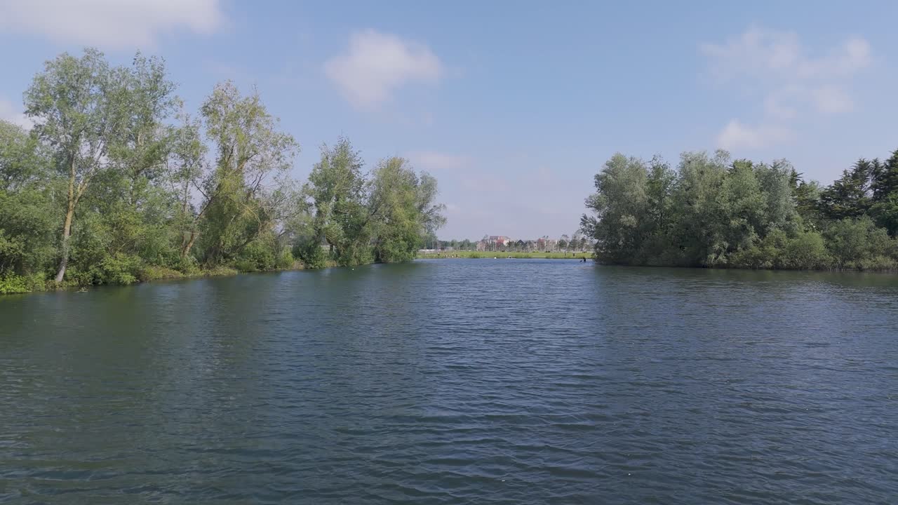 Drone footage flying just above the lakefront, gradually zooming up to reveal the surrounding landscape and natural beauty. Perfect for showcasing stunning scenery and location views.