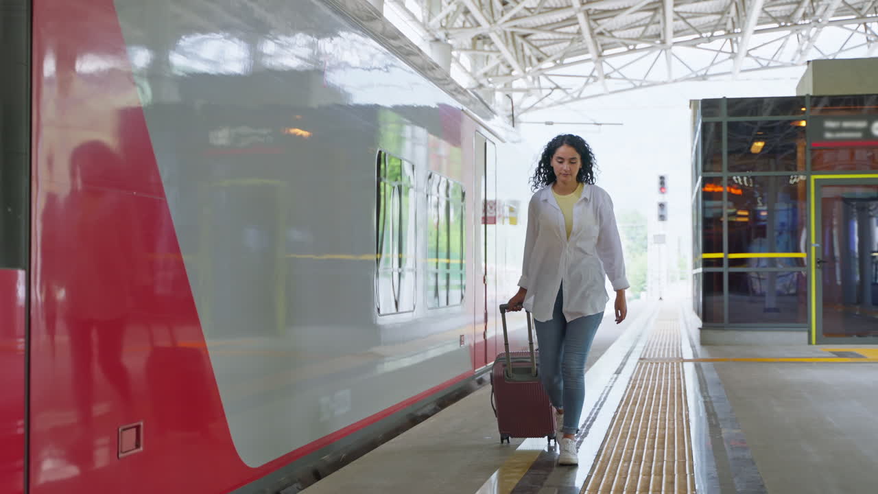mujer caminando con una maleta en la estación de tren