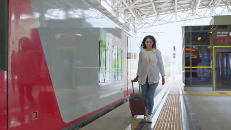 woman walking with suitcase at train station