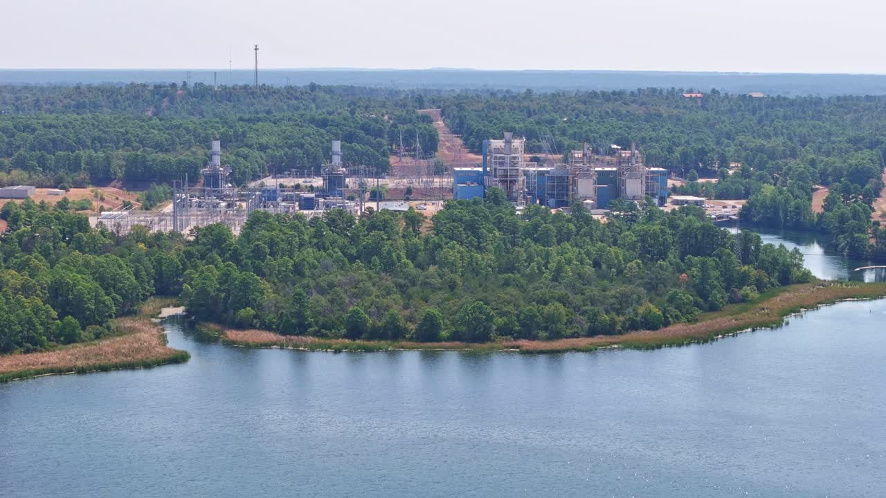 moviéndose a la derecha sobre un lago que tiene una planta de energía detrás de ella