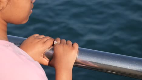child looking at the ocean from a boat
