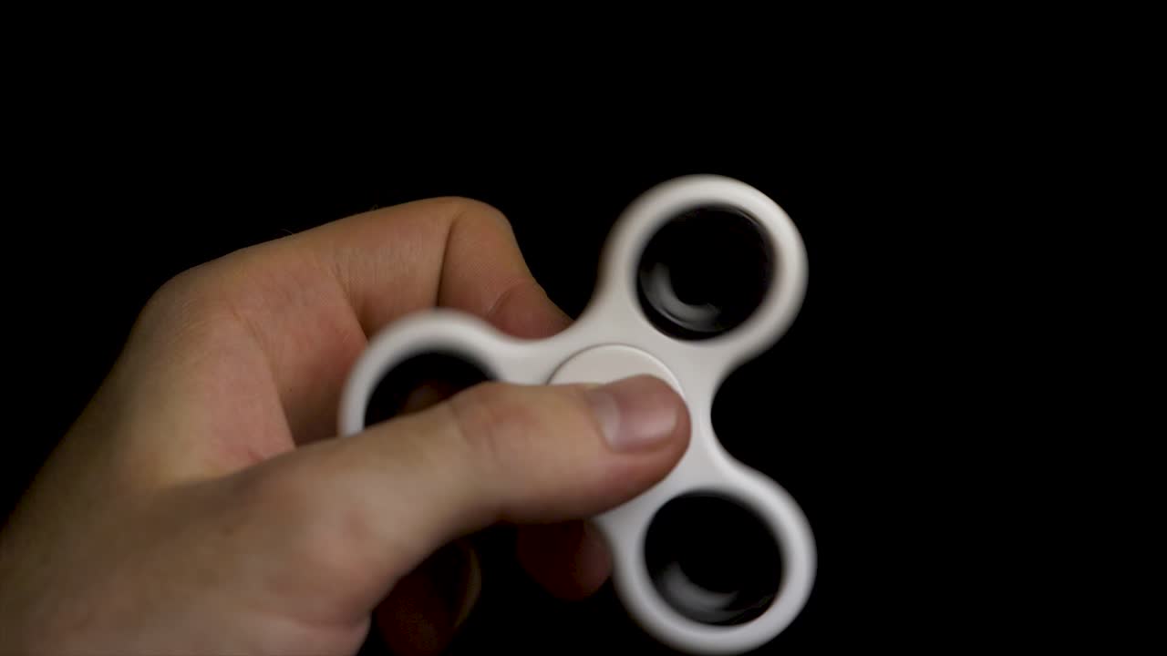 Person spinning a white fidget spinner
