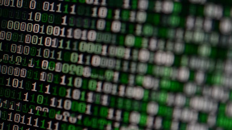 Codice binario sullo schermo del monitor. Sfondo con ripresa di codice binario
