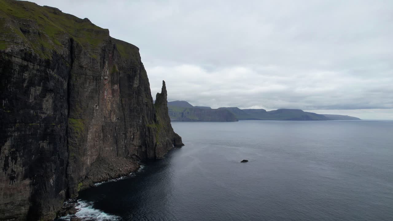 tomada aérea de 4k de la épica costa escarpada en trollkonufingur sea stack, islas feroe