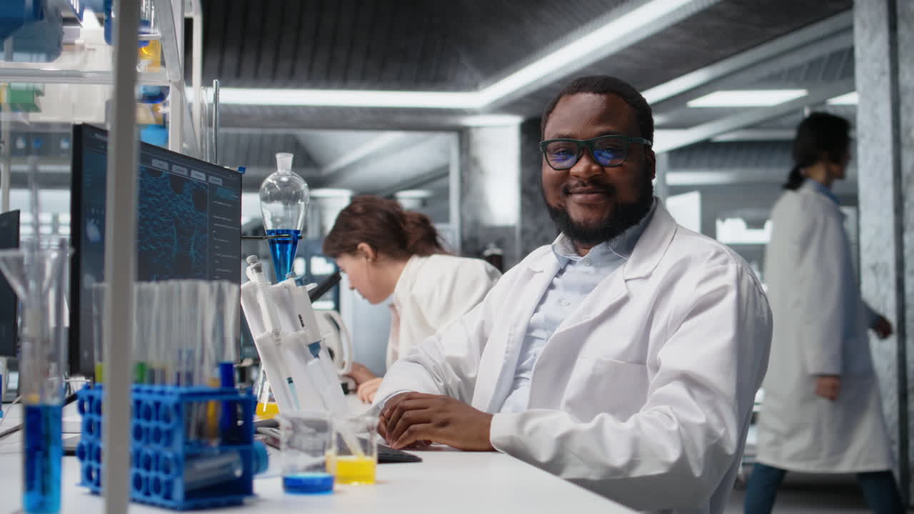 Vertical video Portrait of smiling laboratory scientist using computer
