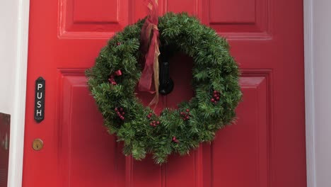 green chrismas wreath on the red door of charles dickens museum in king's cross, london borough of camden, uk
