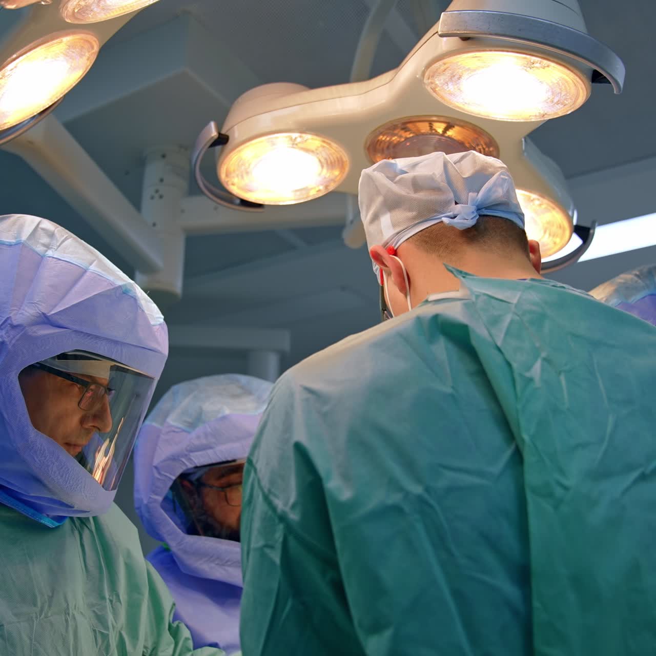 Sundhedsfagligt team samarbejder på operationsstuen. Frøperspektiv af en gruppe kirurger, der udfører operation