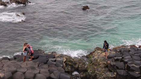 group of people navigating rocky seaside landscape