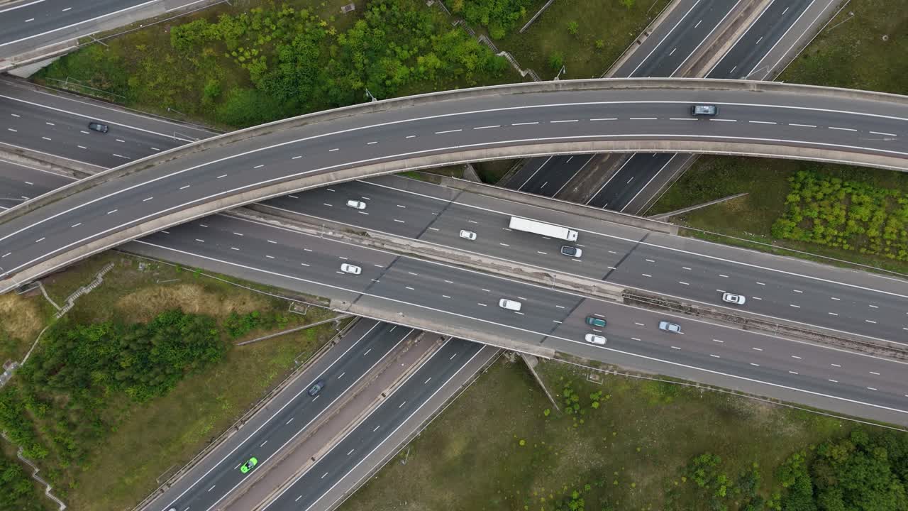 Cinematic aerial drone view of traffic at a complex highway interchange with junctions, flyovers, and crossovers in England UK
