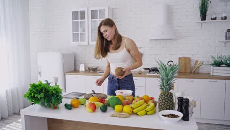 woman with coconut in kitchen. happy young woman in kitchen with coconut in hand
