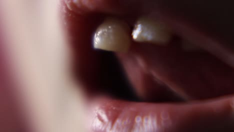 macro close up of young girl wiggling loose front teeth