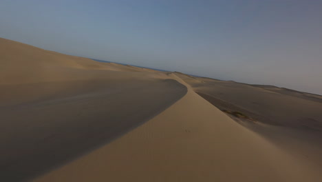 vuelo aéreo rápido y bajo sobre las dunas de arena al atardecer