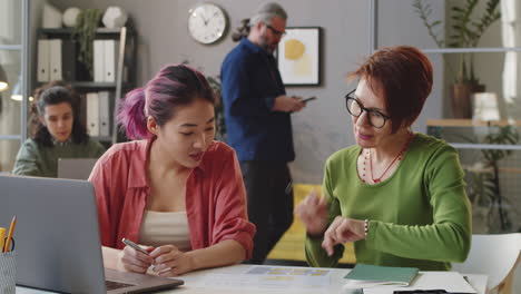 entrenada asiática trabajando con un mentor en la oficina