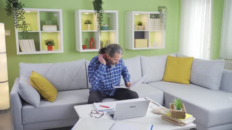 Mature-freelancer-man-working-on-computer-and-project-documents-at-home.