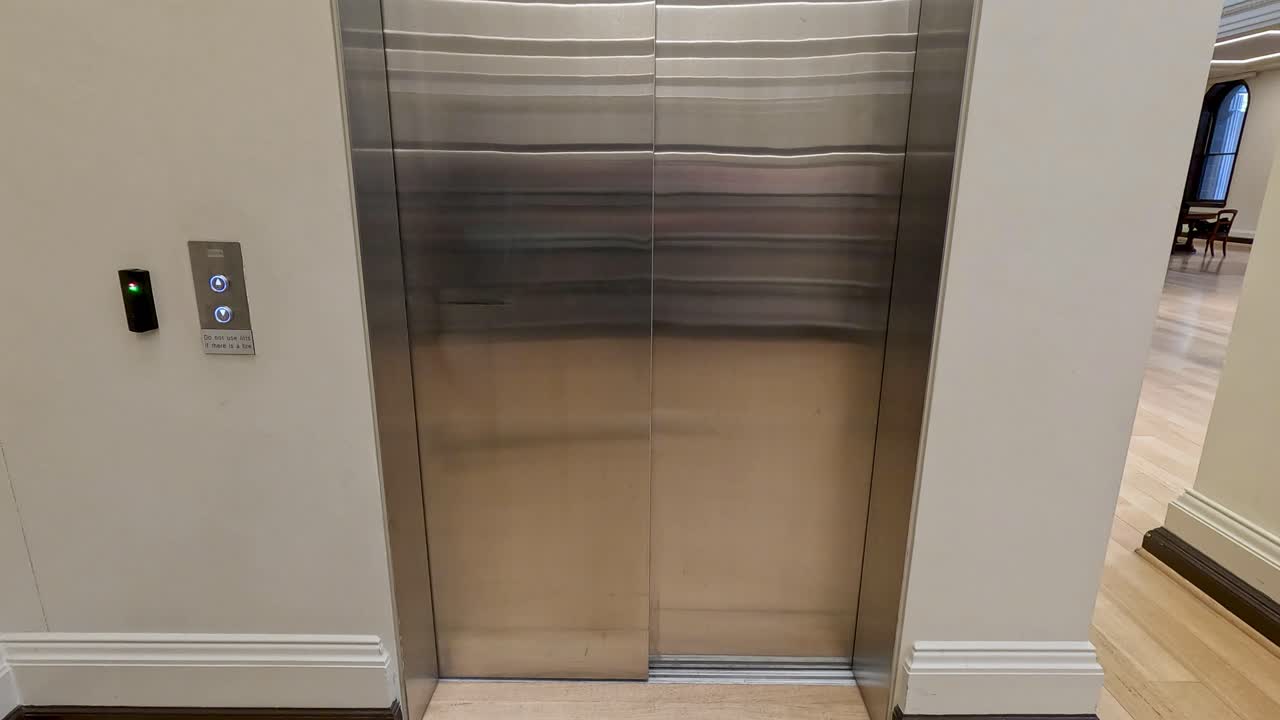 Person enters and operates elevator in library