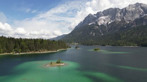 Vista-Aérea-Del-Vibrante-Lago-Eibsee-En-Bayern,-Alemania,-Con-Pequeñas-Islas-Esparcidas-Por-El-Agua-Y-Rodeadas-De-Bosques-Montañosos,-El-Concepto-De-Belleza-Natural-Y-Tranquilidad