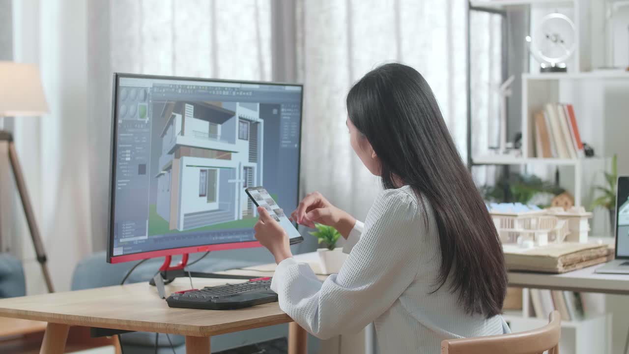 아시아 여성 엔지니어가 집을 디자인하는 동안 스마트 폰을 사용합니다.