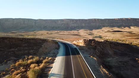 aerial: drone view over a deserted road in the middle of the ramon crater canyons, makhtesh ramon in israel