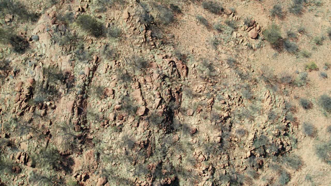 Drone view looking directly downwards of the dry rocky landscape north of Alice Springs, Mparntwe. Northern Territory, Australia. August 2022.