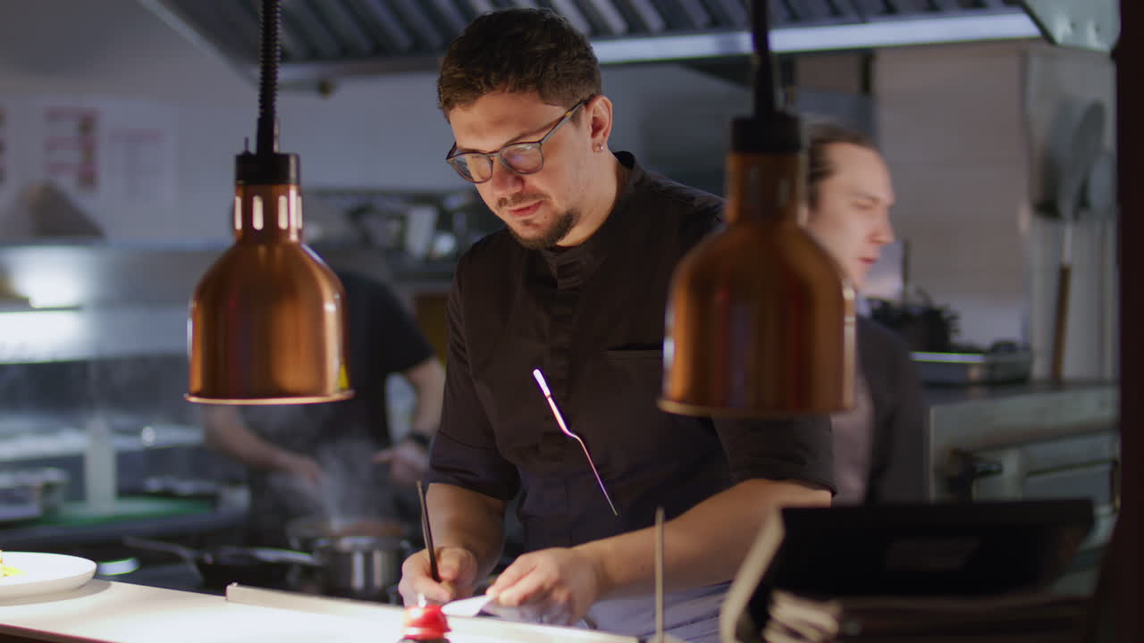 Chef legge la comanda e prende appunti nella cucina del ristorante.