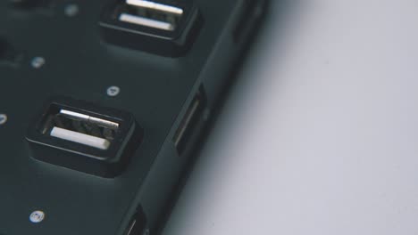 man takes off usb cable from black hub on white background