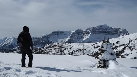 Hombre-Caminando-En-La-Nieve-En-La-Cima-De-La-Montaña