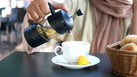 woman pouring tea in a cafe