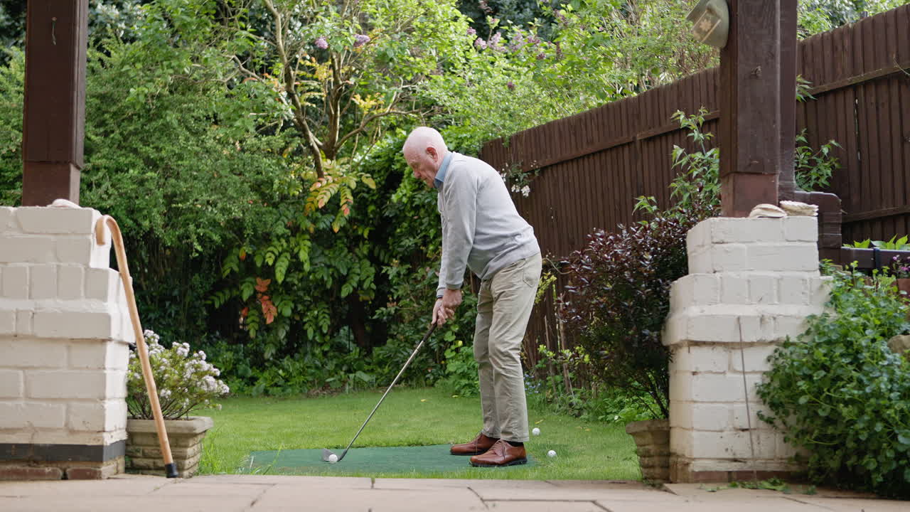 Senior man playing golf in garden