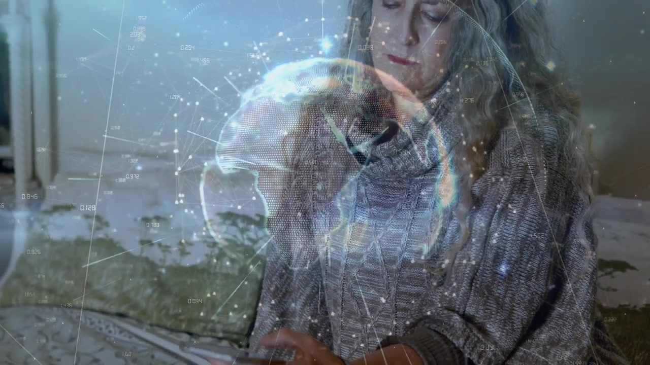 Volwassen vrouw zit op bed, stelt haar telefoon in en veroorzaakt hologlobe-groei boven haar handen voor een tech-demo.