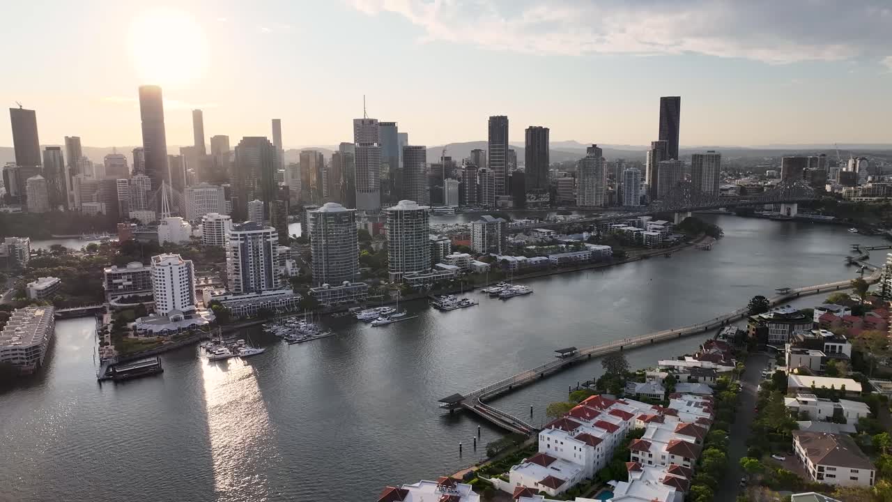 Brisbane, Australia. Drone pull back over the river, residential area with promenade in the evening.