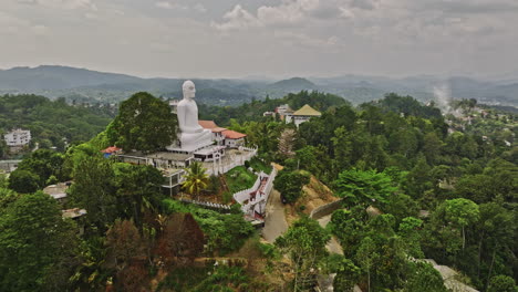 Kandy,-Sri-Lanka:-Luftaufnahme-Einer-V16-Drohne,-Die-Um-Einen-Buddhistischen-Tempel-Auf-Einem-Hügel-Fliegt-Und-Die-über-Dem-Gebäude-Thronende-Buddha-Skulptur-Mit-Panoramablick-Auf-Die-Innenstadt-Einfängt-–-Aufgenommen-Mit-Mavic-3-Cine-–-April-2023