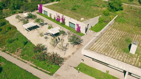 aerial view dolly in of a building set by the vegetation with a roof garden in the middle of the forest, contemporary architecture
