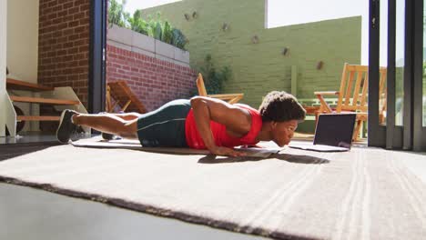 hombre afroamericano en forma haciendo ejercicio en casa y haciendo abdominales