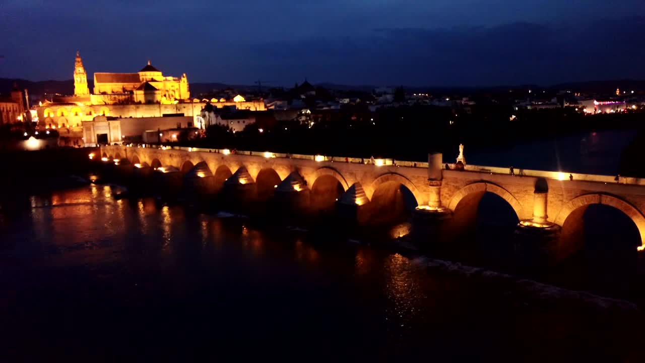 과달키비르 강을 가로지르는 로마의 다리가 조명된 풍경적인 공중 풍경