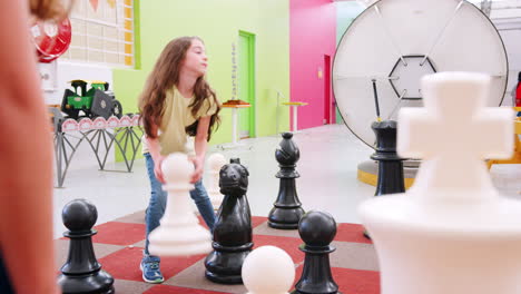 Young-girl-moving-giant-chess-pieces-at-a-science-centre