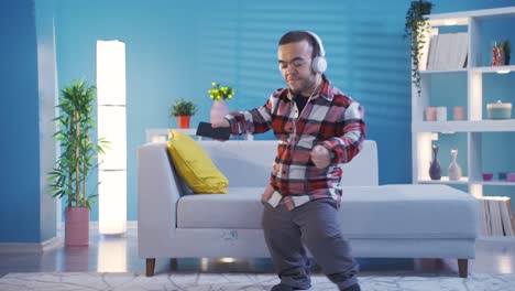 cheerful disabled dwarf young man dancing while listening to music with headphones.
