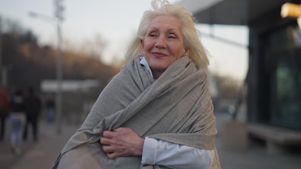 Elderly woman wrapped in shawl on the street