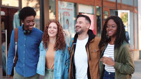 group of multiethnic friends laughing and walking down the street