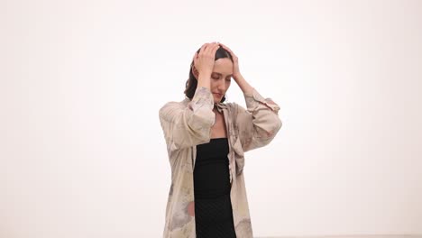 a woman holding her head in distress against a white background