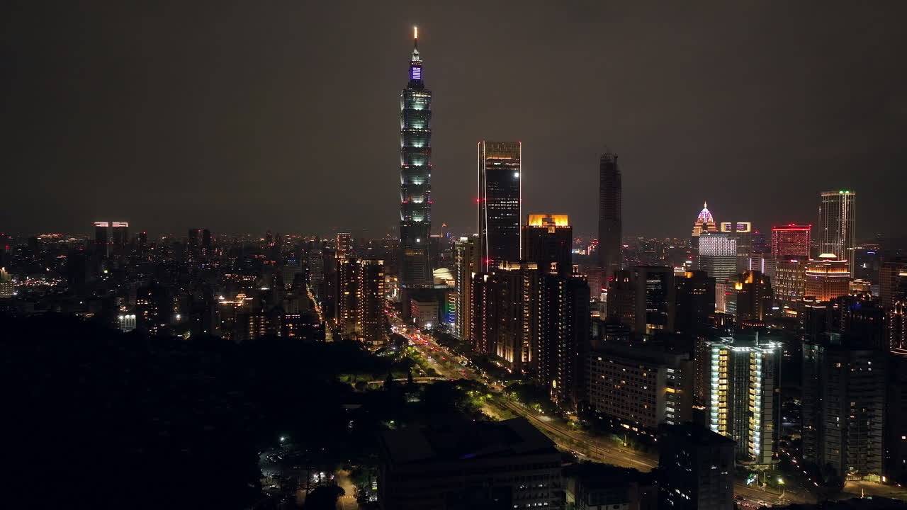 Spectacular skyline of Taipei at night with flashing lights of buildings - aerial wide shot