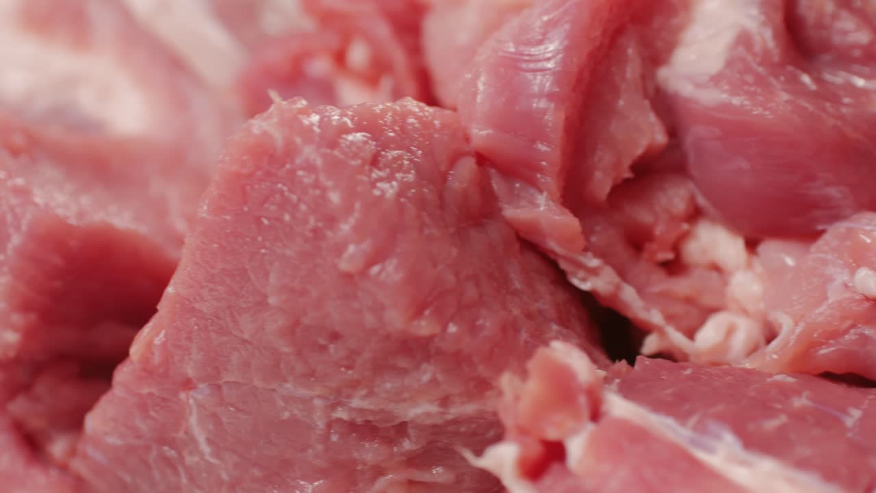 Chef Butcher cutting pork meat with knife on kitchen, cooking Mexican traditional food. Man cut big beef piece for barbecue bbq.